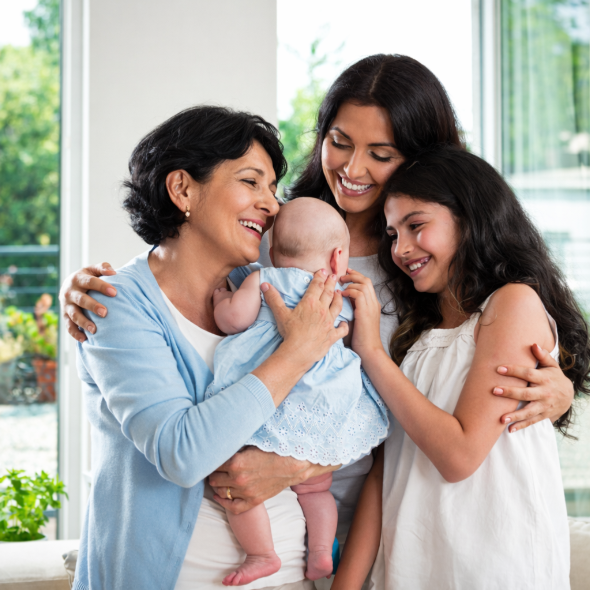 Group of women of different ages including grandmother, mother, and young girl holding a newborn baby, representing women's healthcare and gynecology services for every stage of life.